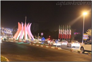 Автомобильное движение и флаги Ирана на острове Киш ночью