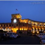 Главные часы Еревана на башне с флагом. Площадь Республики вечером