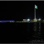Вид на флаг Азербайджана и морской порт в Баку ночью